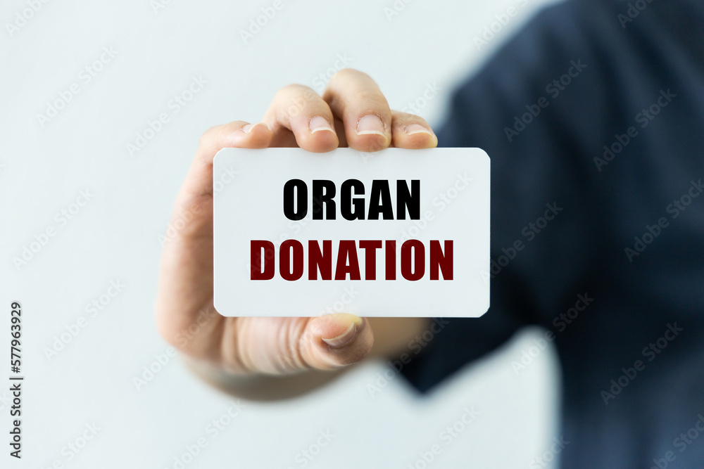Organ donation text on blank business card being held by a woman's hand with blurred background. Business concept about organ donation. Organ donation text on blank business card being held by a woman's hand with blurred background. Business concept about organ donation.