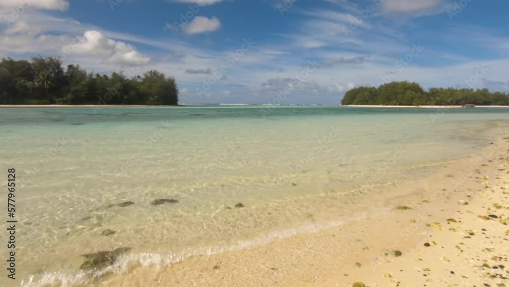 horizontal view of look out from Muri Beach Cook Islands to Koromiri and Oneroa islets within lagoon with calm sea turquoise blue water and rocky sandy beach shore during day sunshine cloud cast horizontal view of look out from Muri Beach Cook Islands to Koromiri and Oneroa islets within lagoon with calm sea turquoise blue water and rocky sandy beach shore during day sunshine cloud cast