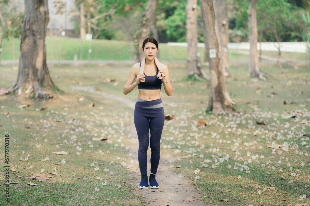 Asian woman running in park.