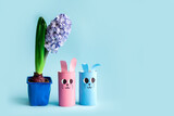 Holiday easy DIY craft idea for kids. Toilet paper roll tube toy's cute rabbit's, hyacint flower on blue background. Creative Easter decoration eco-friendly, reuse, recycle handmade minimal concept