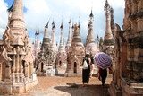 Kakku, Myanmar, con dos turistas y un parasol entre las pagodas esculpidas de piedra