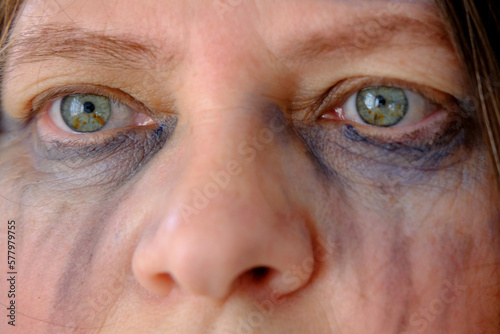 close-up of female tear-stained face, beaten woman with bruises and abrasions, quiet cry for help, concept of domestic violence, emotion of suffering from pain, kidnapping, being in danger