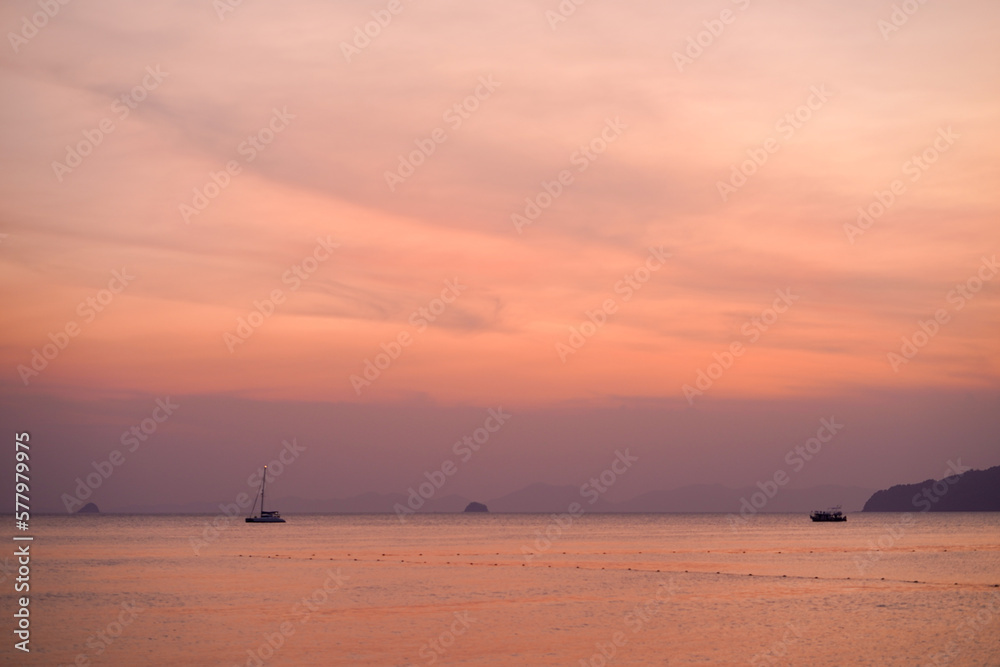 selective focus of vanilla sky with sunset on the beach as foreground