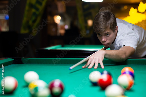 Young man playing pool in pub
