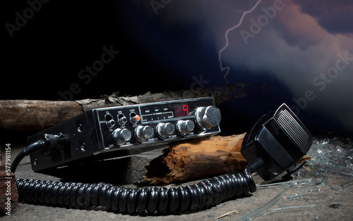 Debris around a two way radio with storm behind photo