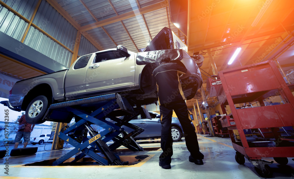 Car on hydraulic lift in auto repair shop Car on hydraulic lift in auto repair shop