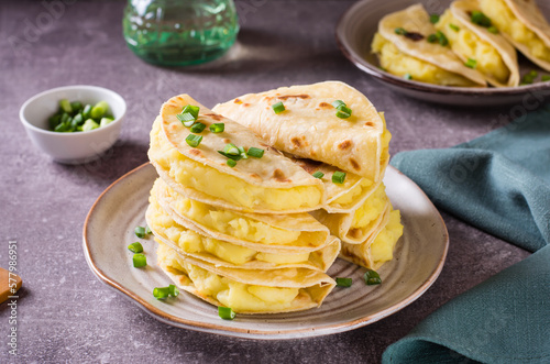 A stack of Kystyby - thin flatbread filled with mashed potatoes and onions on a plate. photo