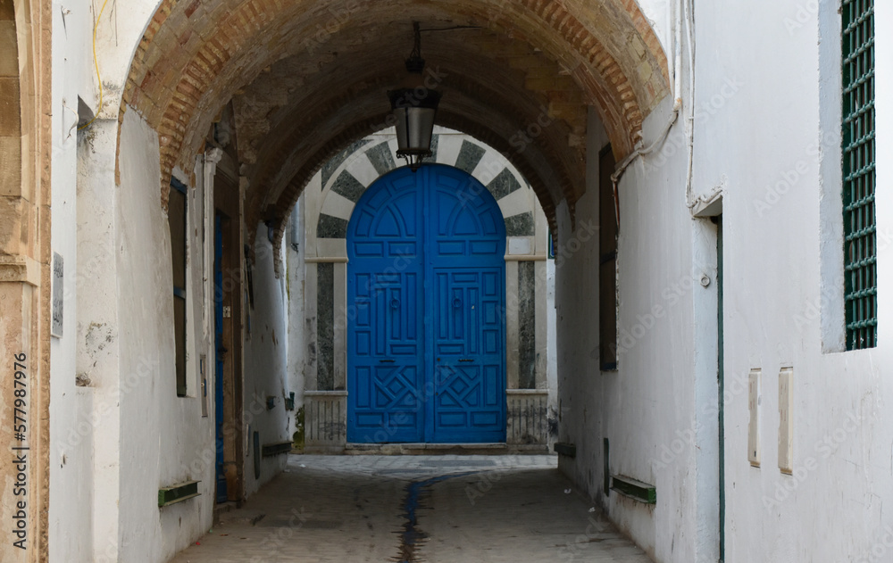 Alley in Tunis Medina with Traditional Blue Door with Black and White Arch at the End