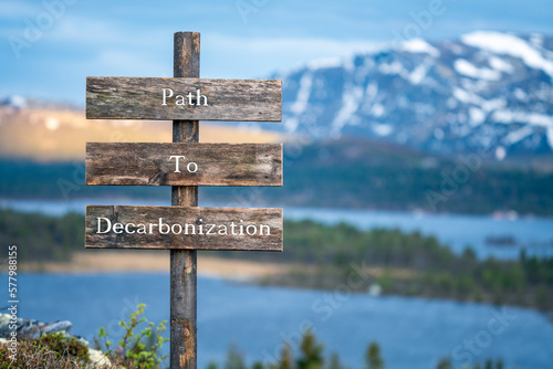path to decarbonization text quote on wooden signpost outdoors in nature during blue hour. photo
