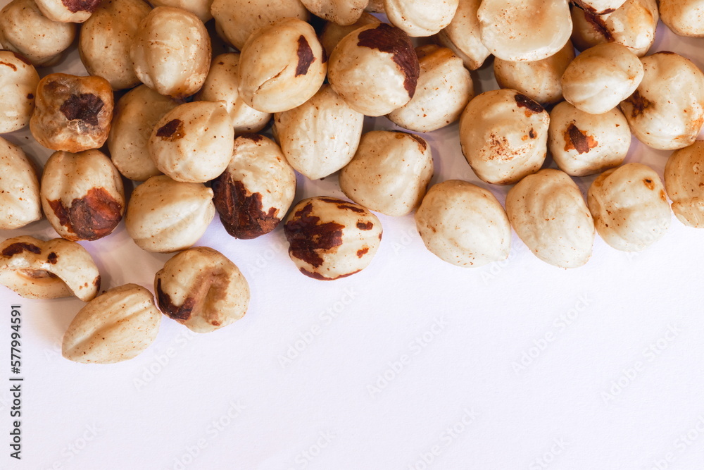 Peeled hazelnuts on a white background. Poorly peeled hazelnuts.