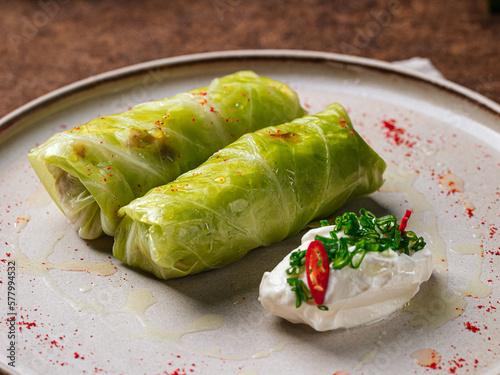 Portion of russian stuffed cabbage leaves golubtsy with sour cream