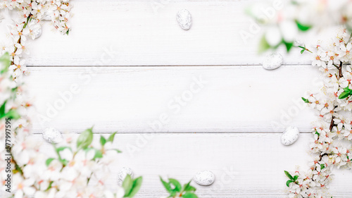 Easter flat. Cherry tree blossom, white happy easter eggs on wood spring background. Springtime concept. 