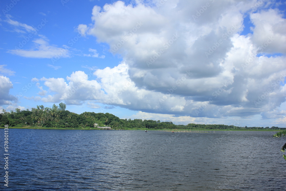 This is a natural photo wallpaper captured in a village in Bangladesh. A user can use this as a natural background. Because, this contains natural beauty. It also contains river and sky with clouds.