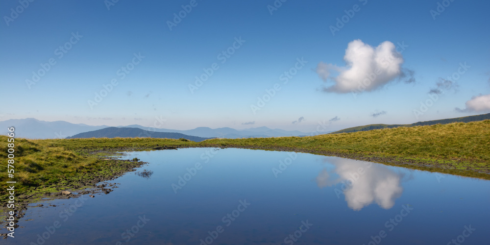 pond in mountains. beautiful countryside landscape of transcarpathia. clouds above horizon on a warm sunny day