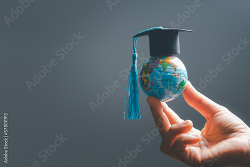 Fototapeta Naklejka Na Ścianę i Meble -  Graduation cap with Earth globe. Concept of global business study, abroad educational, Back to School. Education in Global world, Study abroad business in universities in worldwide. language study