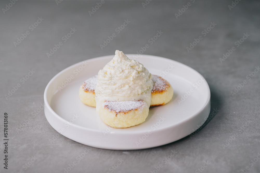 Cheese pancakes with Espuma on a plate Cheese pancakes with Espuma on a plate