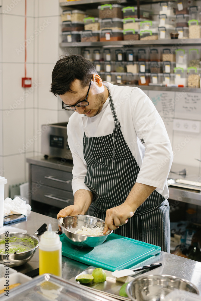 The chef prepares food in the modern spacious kitchen. The chef prepares food in the modern spacious kitchen.