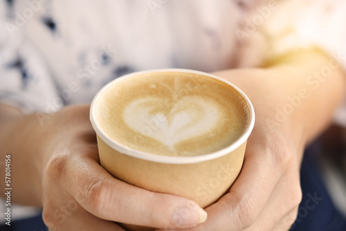 Close up view, Warm coffee cup to morning with woman hand.