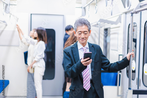 電車内でメールを送るビジネスマン