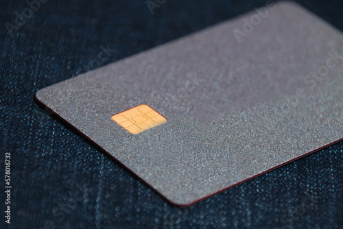 Bank card with a modern chip on a denim background. Concept of safe online operations with bank accounts and protection of bank cards from fraudsters