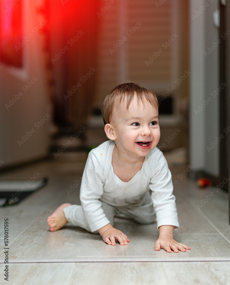 Playful little child on the floor. Joyful happy son having fun on the floor.