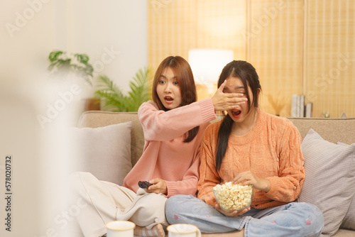 Friendship concept  LGBT lesbian couple covering eyes of girlfriend while watching horror movie