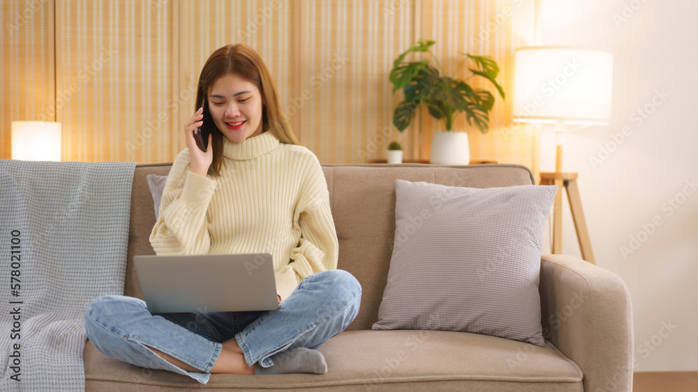 Winter holiday concept, Women are working on laptop and talking on smartphone near christmas tree