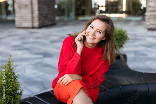 Young attractive woman laughs merrily talking on a smartphone