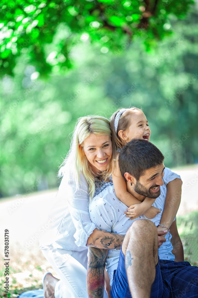 A happy family enjoying nature and having fun with their daughter