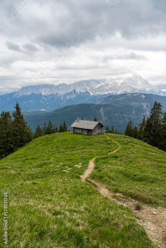 Hütte auf Almwiese in den Vergen mit Pfad oder Weg und Bergpanorama. © hannesheigl