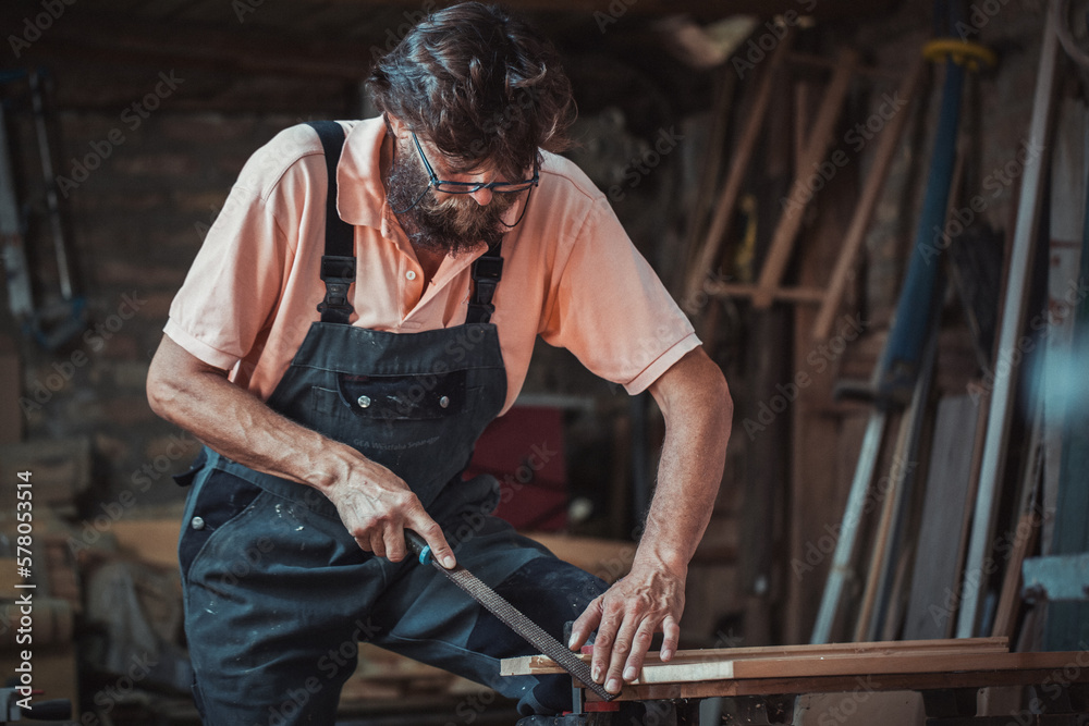 Carpenter using working tools while working on a wood in carpentry workshop Carpenter using working tools while working on a wood in carpentry workshop