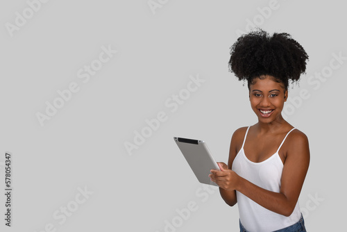 woman with a tablet computer, smiling looks at the camera on a gray background