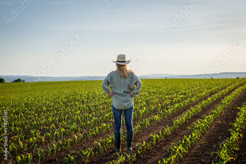 Satisfied farmer is looking to corn field at her organic farm