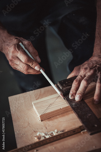 Carpenter using working tools while working on a wood in carpentry workshop