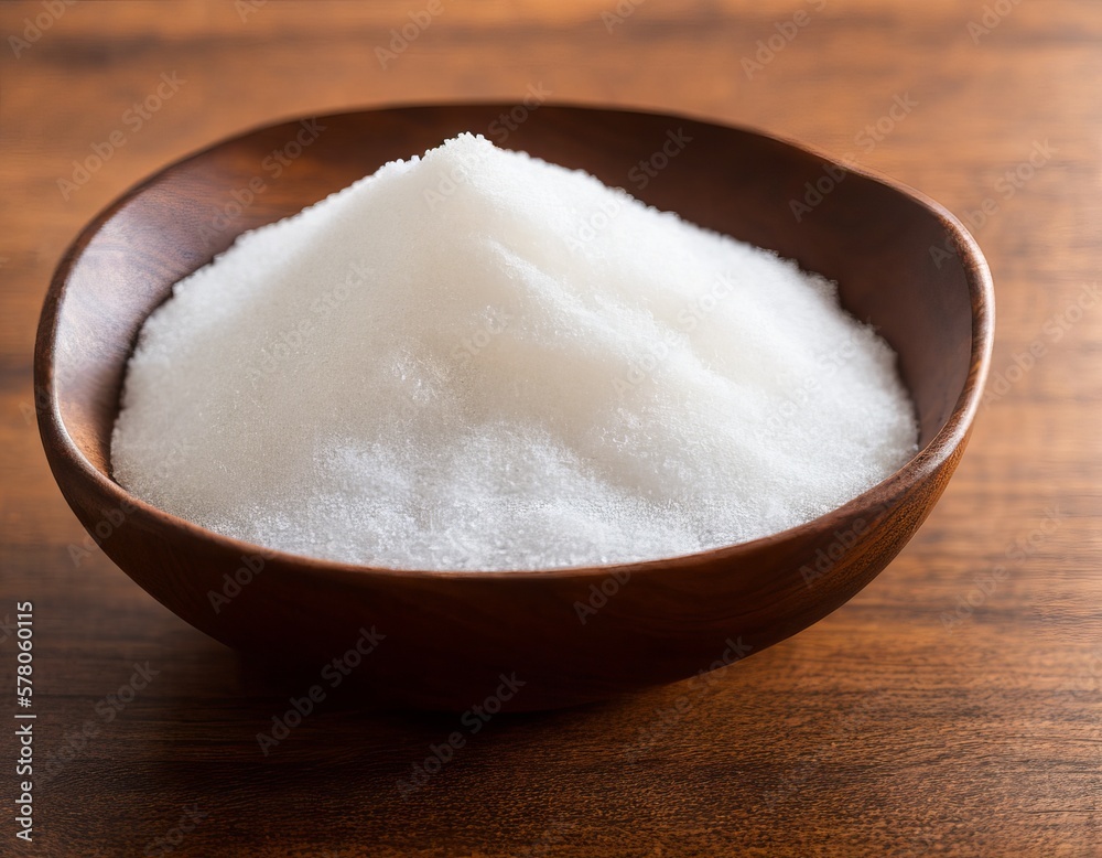 sea salt in a wooden spoon on a brown background
