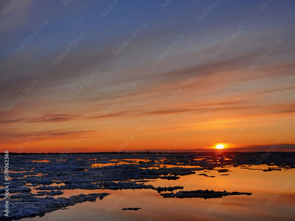 Ice drift, ice floes float on the river in early spring, Ice drift on the river in the orange light of the evening sun. Ice drift, ice floes float on the river in early spring, Ice drift on the river in the orange light of the evening sun.