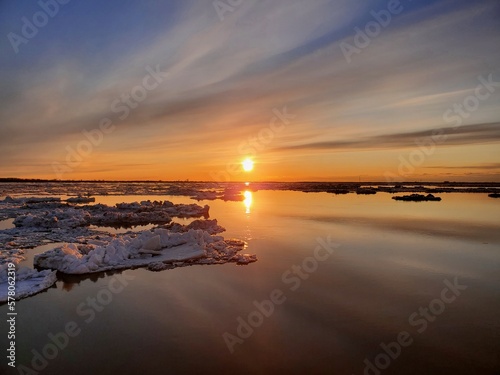 Ice drift  ice floes float on the river in early spring  Ice drift on the river in the orange light of the evening sun.