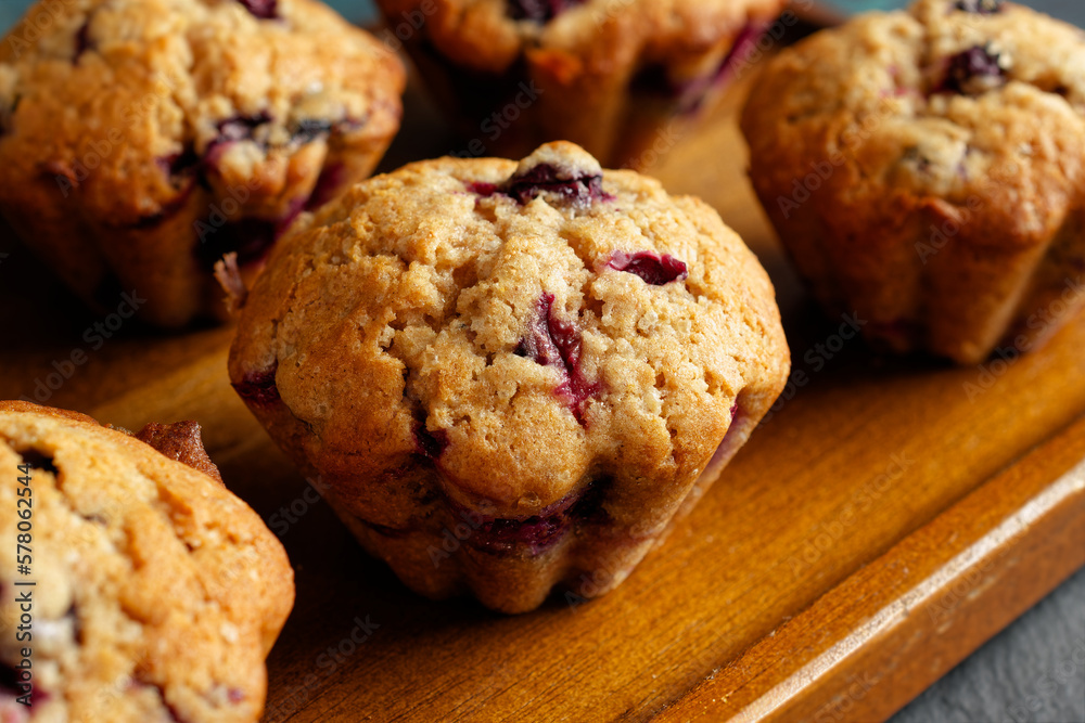 Homemade blueberry muffins on a wooden serving tray. Close-up. Homemade blueberry muffins on a wooden serving tray. Close-up.