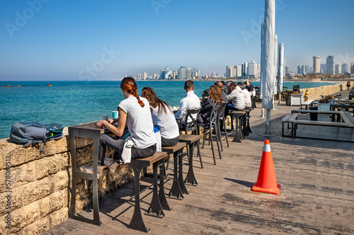 Stampa su tela Coffee shop at Old Jaffa embankment over Mediterranean sea and Tel Aviv skyline