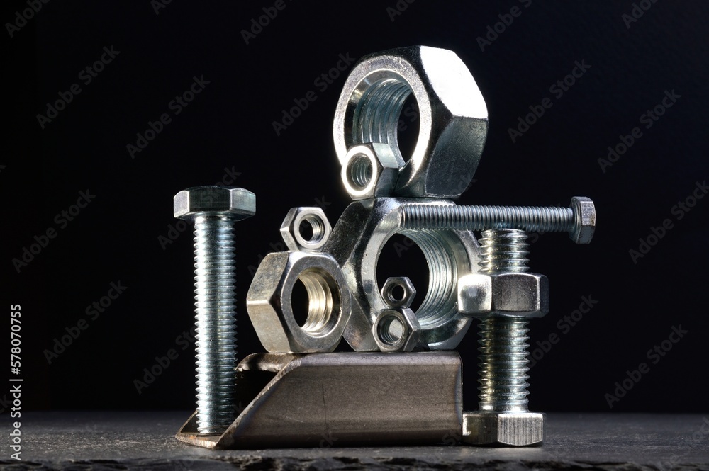 composition of nuts bolts and scraps of metal laid out on a dark background. composition of nuts bolts and scraps of metal laid out on a dark background.