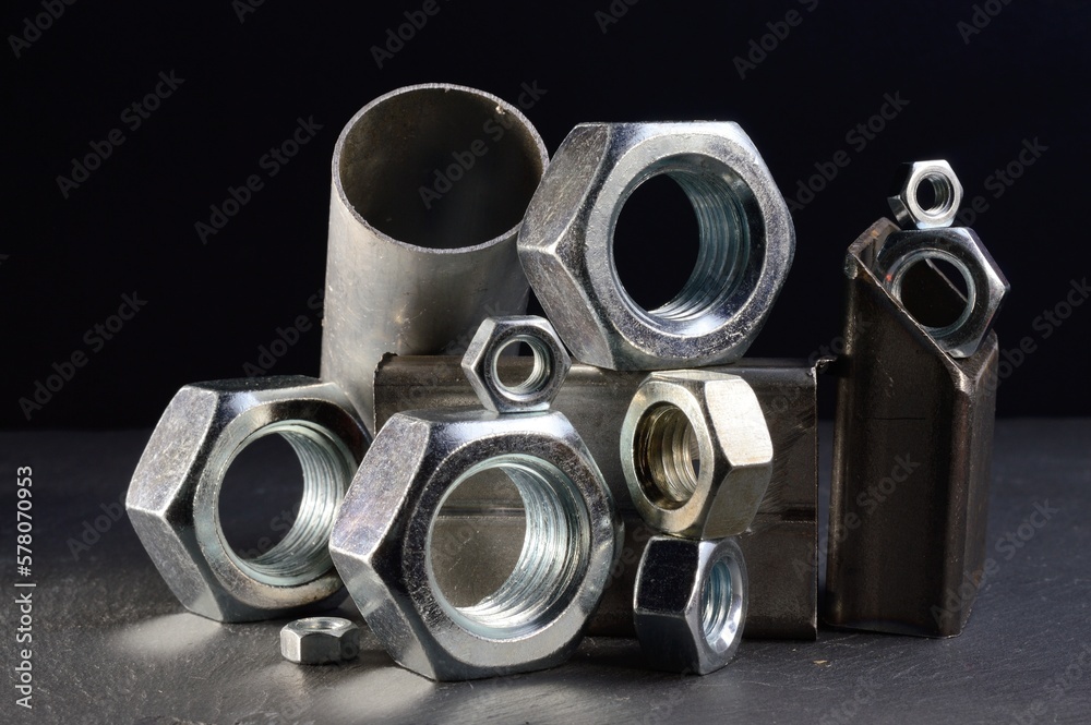 composition of nuts bolts and scraps of metal laid out on a dark background. composition of nuts bolts and scraps of metal laid out on a dark background.