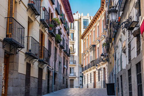 Picturesque alley with old buildings, windows and terraces with bars in the city of Madrid, Spain.