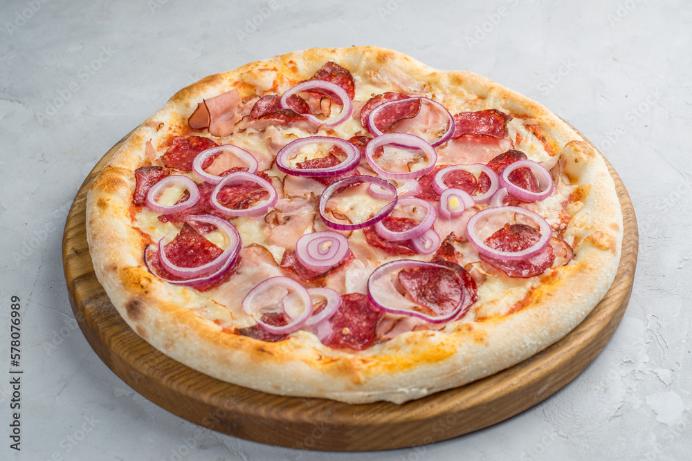 Pizza with vegetables, sausages and ham
