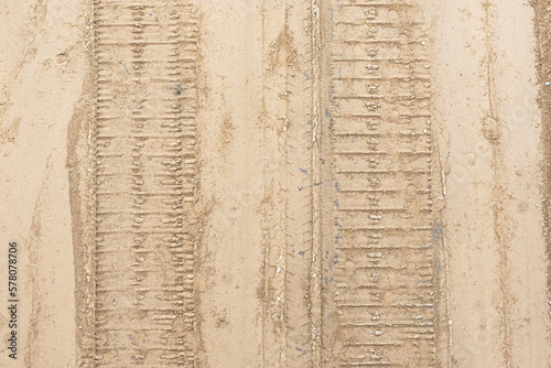 Mud tyre mark background. Wet sand tire print texture. Ttrail track pattern.Metal excavator track background. Construction site sandy ground. House building background. Heavy machinery equipment.