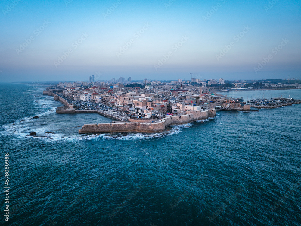 Acre (Akko) is a port city located on the Mediterranean coast and is known for its well-preserved ancient city fortifications. .Aerial footage of the old city, the ancient port and marina.