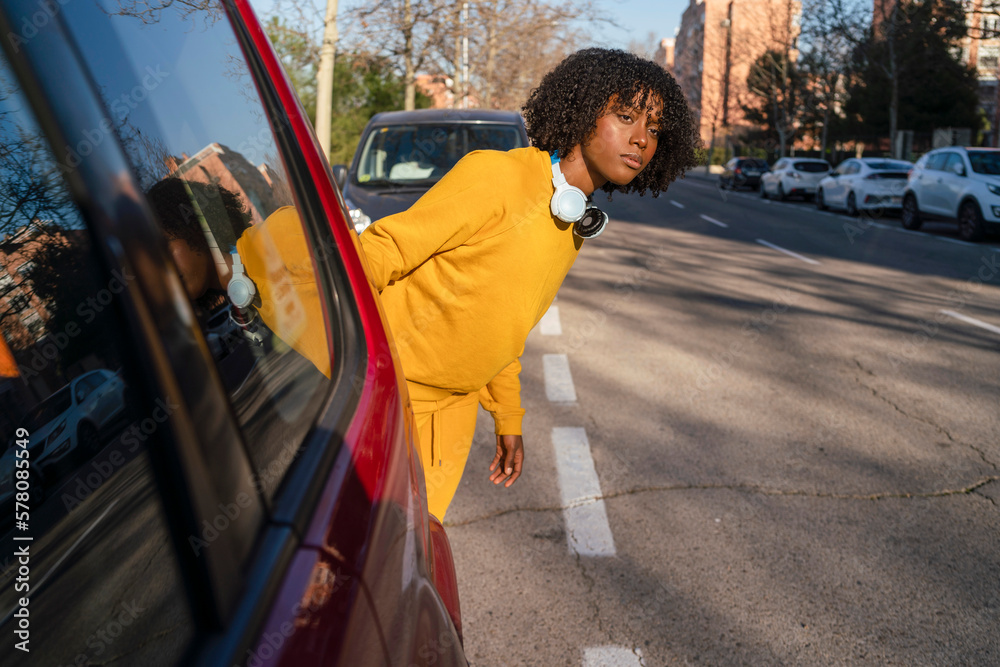 Obraz premium A girl runner trying to cross the road between cars.