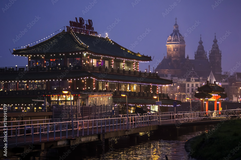 Chinese restaurant at night with cathedral in the background, Amsterdam, Netherlands