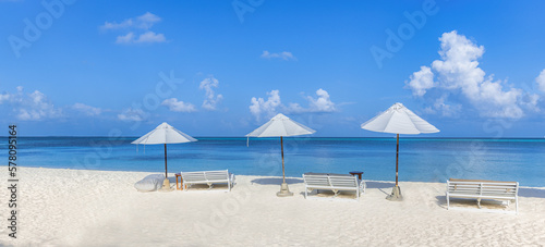 Beach lifestyle. Idyllic panoramic landscape shore coast Mediterranean tropical scene. Sunny umbrella chairs, beach beds, tranquil leisure vacation background panorama. Exotic carefree freedom holiday