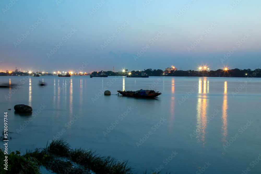 Boat in the river Ganges at Kolkata. Photo has been taken in Kolkata at West Bengal in beautiful blue light at evening. Boat in the river Ganges at Kolkata. Photo has been taken in Kolkata at West Bengal in beautiful blue light at evening.