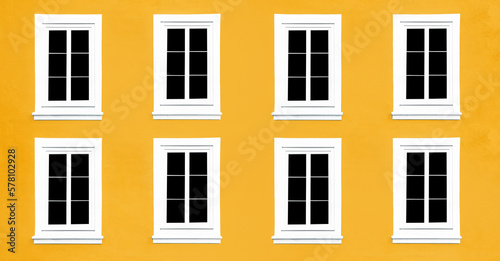 PVC Windows. Architecture background. Vibrant color yellow wall facade. Small town house exterior. Street of European city building. Eight window frames isolated on empty wall. Simple windows in a row